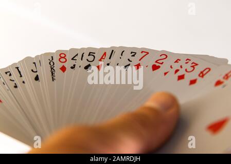Karten in der Hand isoliert auf weißem Hintergrund spielen. Stockfoto