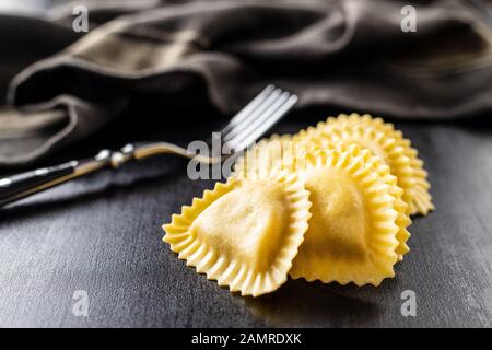 Italienische Teigwaren. Panzerotti-Pasta auf schwarzem Tisch. Stockfoto