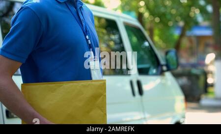 Person in einem einheitlichen Umschlag mit Dokumenten, Büroanlieferung, Service Stockfoto