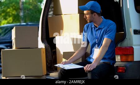 Postmitarbeiter, die den Bestandsbericht ausfüllen, Kartons zählen, Lieferung Stockfoto