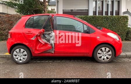 Paris, Frankreich - 27. Dezember 2019: Seitenansicht des neuen, durch Unfall zerstörten roten Kleinwagens Toyota hinter der Tür zerschlagen - regnerischer Tag Stockfoto