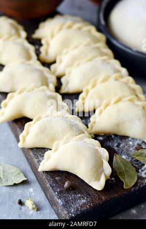 Knödel mit Kartoffeln mit Kräutern auf einem blauen Hintergrund. Wareniki, vareniki, Pierogi, pyrohy-Knödel mit Füllung. Stockfoto