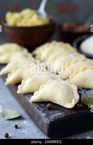 Knödel mit Kartoffeln mit Kräutern auf einem blauen Hintergrund. Wareniki, vareniki, Pierogi, pyrohy-Knödel mit Füllung. Stockfoto