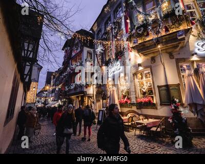 Strasbourg, Frankreich - 24. Dezember 2018: Ultrabreiter Blick auf das Restaurant Le Gruber auf der berühmten Fußgängerzone mit Touristen, die die jährlichen Dekorationen des Weihnachtsmarktes entdecken Stockfoto