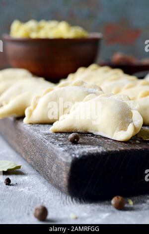 Knödel mit Kartoffeln mit Kräutern auf einem blauen Hintergrund. Wareniki, vareniki, Pierogi, pyrohy-Knödel mit Füllung. Stockfoto