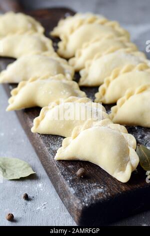 Knödel mit Kartoffeln mit Kräutern auf einem blauen Hintergrund. Wareniki, vareniki, Pierogi, pyrohy-Knödel mit Füllung. Stockfoto