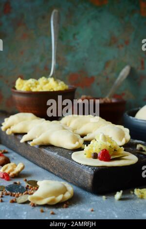 Knödel mit Kartoffeln mit Kräutern auf einem blauen Hintergrund. Wareniki, vareniki, Pierogi, pyrohy-Knödel mit Füllung. Stockfoto