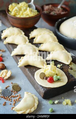 Knödel mit Kartoffeln mit Kräutern auf einem blauen Hintergrund. Wareniki, vareniki, Pierogi, pyrohy-Knödel mit Füllung. Stockfoto