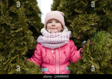 Ein vierjähriges Mädchen im Winter Kleidung mit Hut und Jacke Stockfoto