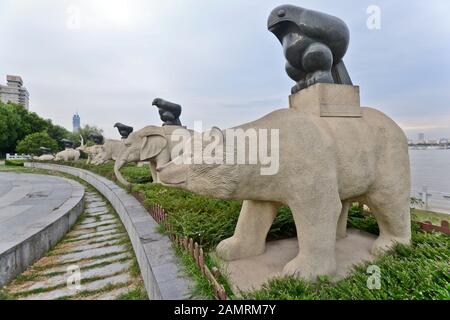 Tierfiguren, die ein Adler-Stativ halten. Dayu Myth Park. Wuhan, China Stockfoto