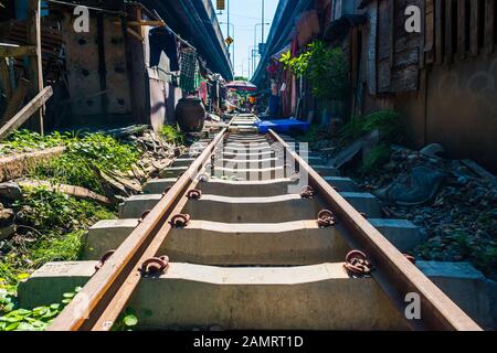 Das Gebiet Khlong toei Slum in Bangkok, Thailand, liegt unter der Autobahn, auf der Bahngleise durch die Nachbarschaft führen Stockfoto