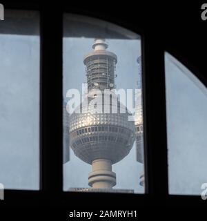 Der Berliner Fernsehturm hinter einem alten Fenster Stockfoto