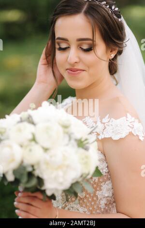 Close up Portrait von wunderschöne Braut mit Blumenstrauß. Glückliche Frau lächeln Stockfoto