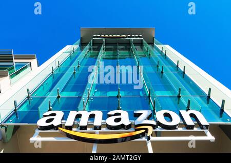 Amazon-Logo mit seinem unverkennbaren orangefarbenen Lächeln auf der Glasfassade des Firmencampus im Silicon Valley Stockfoto