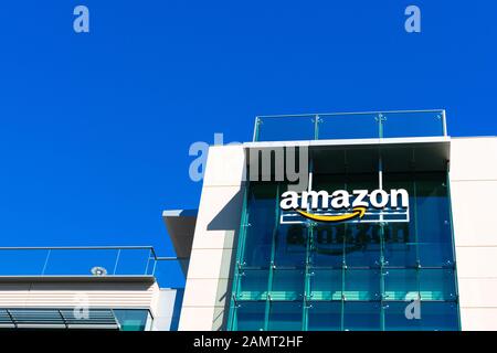 Amazon-Logo mit seinem unverkennbaren orangefarbenen Lächeln auf der Glasfassade des Firmencampus im Silicon Valley - Palo Alto, Kalifornien, USA - Oktober 2019 Stockfoto