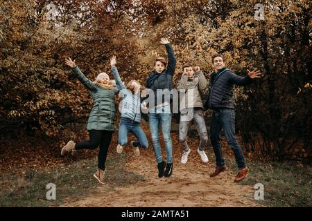 Porträt einer Familie, die in der ländlichen Landschaft, Niederlande, in die Luft springt Stockfoto