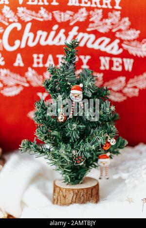 Miniatur-Weihnachtsbaum vor einem Kissen Stockfoto