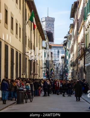 Florenz, Italien - 23. März 2018: Touristenmassen warten auf Museen in der Altstadt von Florenz, mit dem Dom in der Ferne. Stockfoto