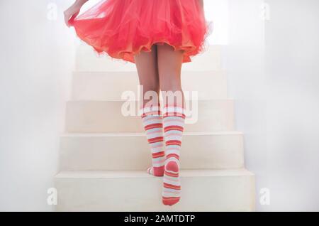 Teenager-Mädchen mit gestreiften Socken, die eine Treppe hinauf gehen Stockfoto