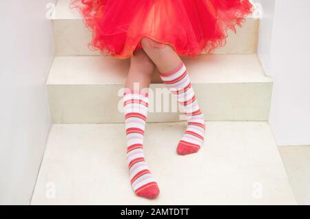 Teenager-Mädchen mit gestreiften Socken auf einer Treppe Stockfoto