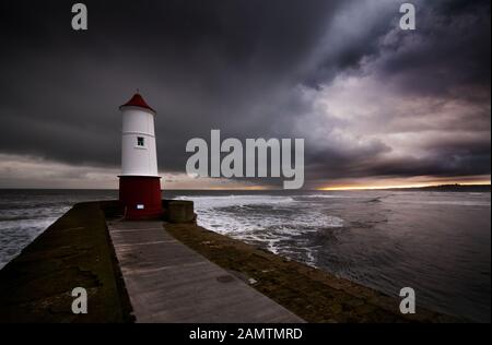 Wetterfront, die über den Leuchtturm am Berwick Pier führt, wo der Fluss Tweed auf die Nordsee trifft Stockfoto