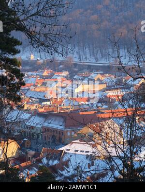 Häuser in der Stadt Brasov, Rumänien, während eines Winteruntergangs - Blick von einer erhöhten Position über der Stadt. Stockfoto