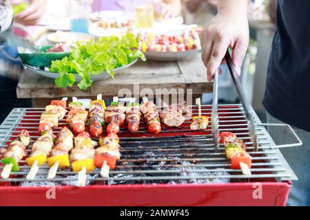 Freunde, die Party machen und Barbecue in Gardern kochen. Stockfoto