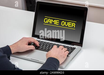 Spiel vorbei, Konzept verwerfen. Mann, der mit einem Computerlaptop arbeitet, Game over Text message on the screen, Office Business Background. Stockfoto