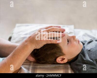 Osteopathie-Behandlung. Elementares Alter die Stirn des Jungen wird von einem echten osteopathischen Arzt manipuliert. Platz für Text kopieren. Stockfoto