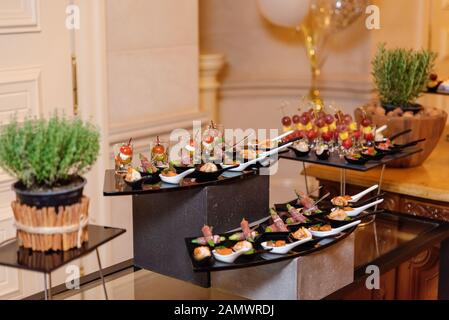 Luxus Snacks auf dem großen Teller. Kleine Portionen und schöne Rollen auf den Bolzen mit Fisch und Speck. Catering Bankett Stockfoto