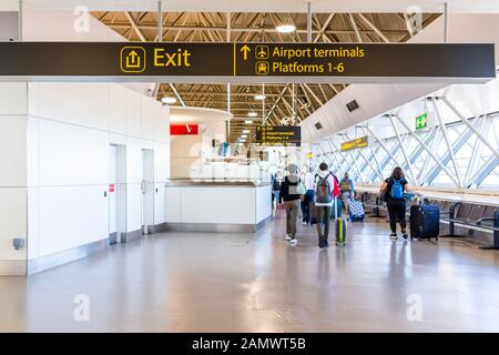 Horley, Großbritannien - 28. Juni 2018: Flughafen Gatwick London mit Menschen, die zu Endbahnsteigen in Gebäudearchitektur und Schild laufen Stockfoto