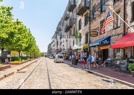 Savannah, USA - 11. Mai 2018: Old Town River Street in Georgia berühmte Südstadt mit Ziegelsteinarchitektur Einkaufsläden Geschäfte Tram Streetcar Stockfoto