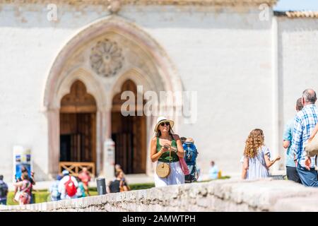 Assisi, Italien - 29. August 2018: Frau Menschen Touristen, die in Umbrien im Stadtdorf durch berühmte Kirche laufen Stockfoto