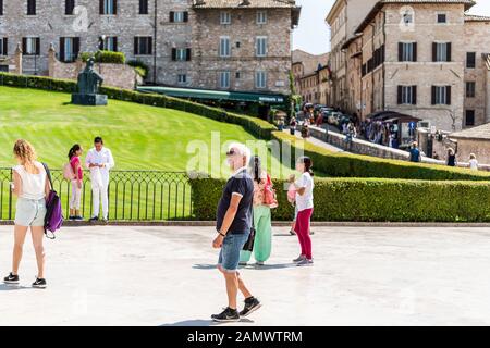 Assisi, Italien - 29. August 2018: Giardini di San Francesco, Gärten des Heiligen Franziskus in der Nähe der Basilika, mit Menschen, die auf dem Platz auf dem grünen Rasen spazieren Stockfoto