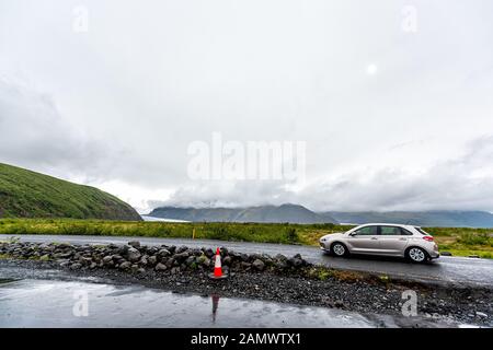 Skaftafell, Island - 15. Juni 2018: Auto auf der Straße in der Nähe des Nationalparks und Svartifoss Wasserfallwanderung mit Menschen im Fahrzeug in der Nähe der Stadt Hof in der Wolke Stockfoto