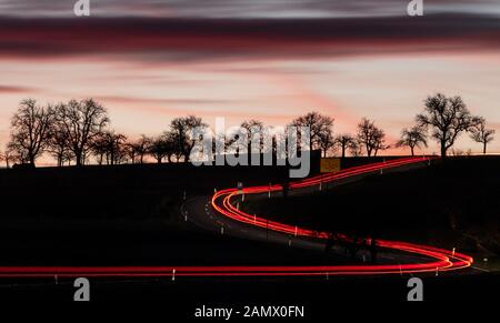 15. Januar 2020, Baden-Württemberg, Vaihingen an der Enz: Autos fahren vor Sonnenaufgang auf einer Landstraße. Foto: Sebastian Gollnow / dpa Stockfoto