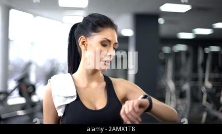 Sportfrau überprüft Puls und verbrannte Kalorien in Smartphone, moderne Technologie Stockfoto