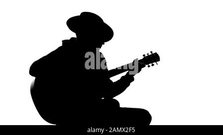Silhouette junger Männer in Hut Gitarre auf Party spielen, cooles Hobby, Freizeit Stockfoto