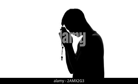 Silhouette des betenden Mannes, der Rosary auf weißem Hintergrund hält, Spiritualität Stockfoto