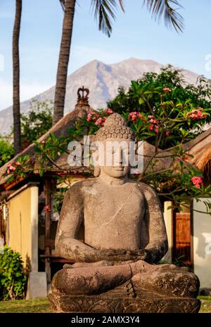 Steinstatue des Buddha mit Berg Agung, Bali, im Hintergrund. Stockfoto