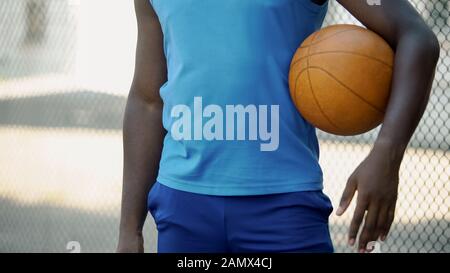Afroamerikanischer Basketballspieler, der den Ball hält, sich auf Spiel und Sport vorbereitet Stockfoto