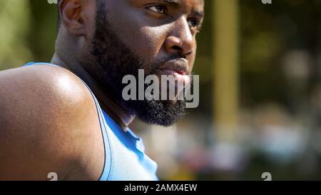 Starker bärtiger afro-amerikanischer Sportler, der ernsthaft nach vorne blickt, aus nächster Nähe Stockfoto