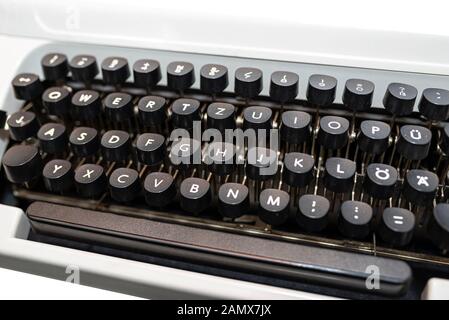 Klassische, manuelle Schreibmaschine in Weiß mit einer deutschen Tastatur Layout, auf einen weißen Hintergrund mit einen Freistellungspfad isoliert. Stockfoto