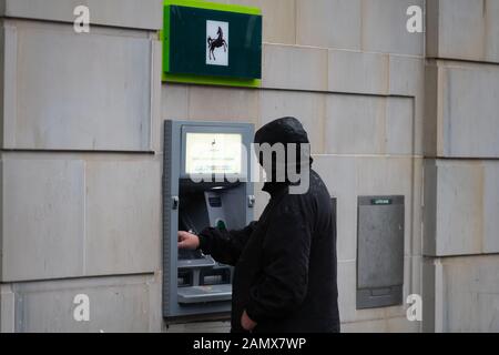 Ein Mann verwendet einen Lloyds TSB-Cashpoint in Großbritannien. Stockfoto