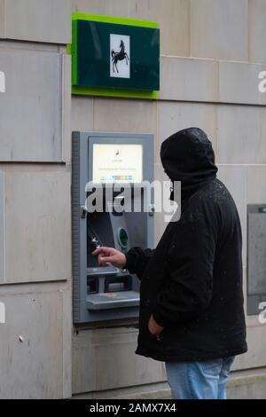 Ein Mann verwendet einen Lloyds TSB-Cashpoint in Großbritannien. Stockfoto