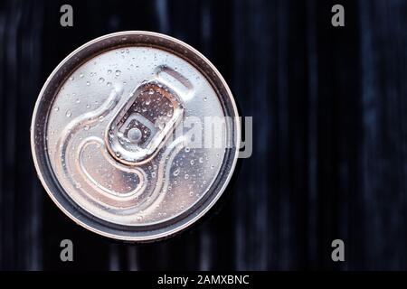 Bierkcan mit Kondensation auf schwarzem Hintergrund. Getränkekank aus Aluminium mit Wassertropfen, gekühlte Cola-Dose, Draufsicht. Textbereich Stockfoto