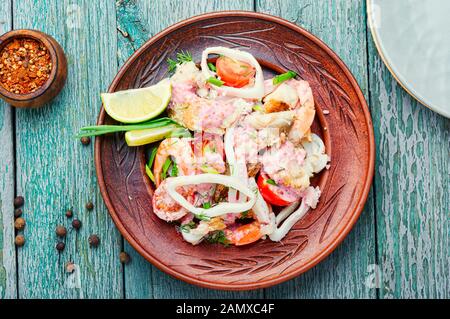 Salat aus Tintenfisch, Fisch und Garnelen auf einem Teller. Hausgemachter Fisch Salat Stockfoto