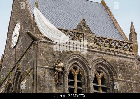 Attrappe des Fallschirmjägers John Steele, der während der alliierten Invasion im zweiten Weltkrieg auf der Spitze der Kirche von Sainte-Mère-Église in der Normandie festsaß Stockfoto