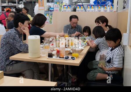 Familie und Menschen essen Thunfisch, Sushi und frische Meeresfrüchte im Makishi Public Market Restaurant in Naha, Okinawa, Japan, Asien. Die japanische Kultur Stockfoto