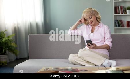 Schöne Senior Lady, die Online-Video auf Smartphone, Gadget-Kommunikation Stockfoto
